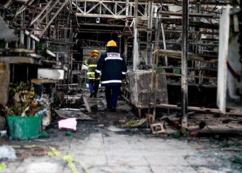 Comerciantes del mercado San Miguelito inspeccionan los daños ocasionados por el incendio.